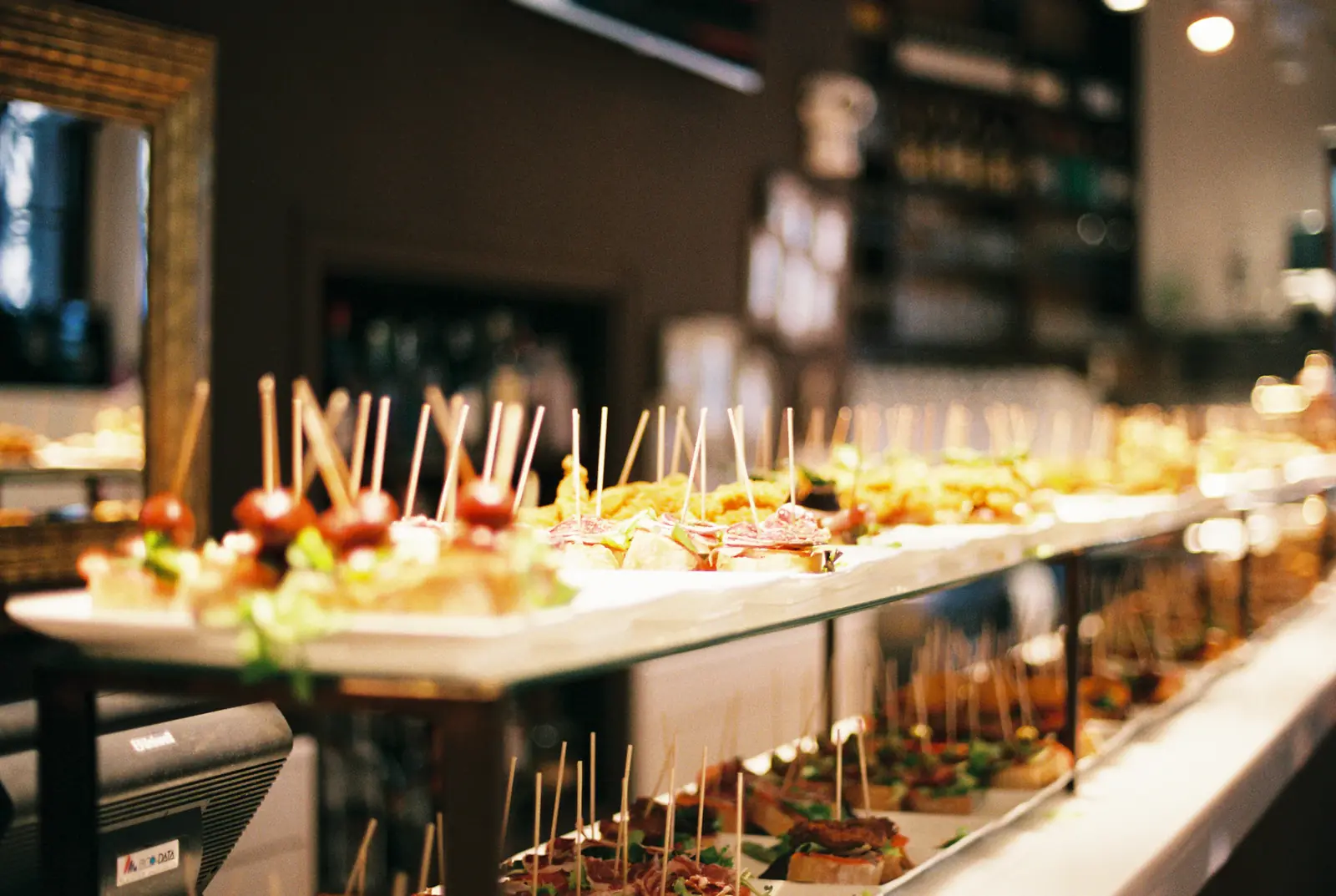 A long catered buffet of skewers and small bites along a counter