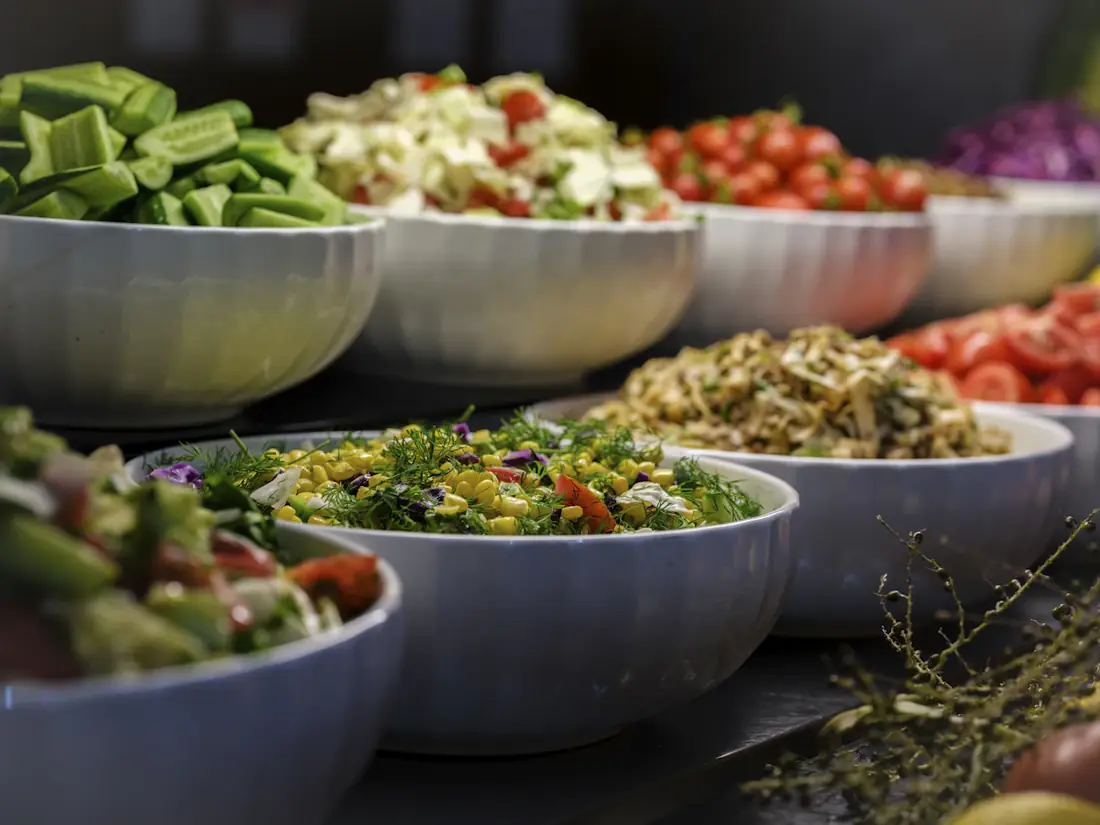 Large bowls of fresh salads lined up on a buffet
